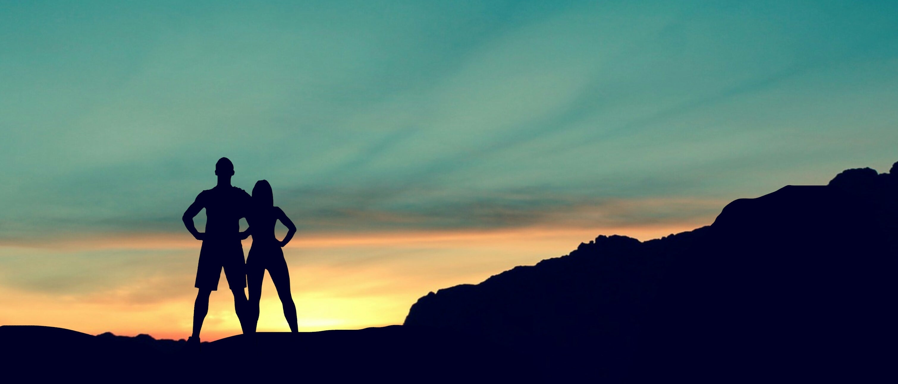 Silhoutted couple at sunset in the mountains